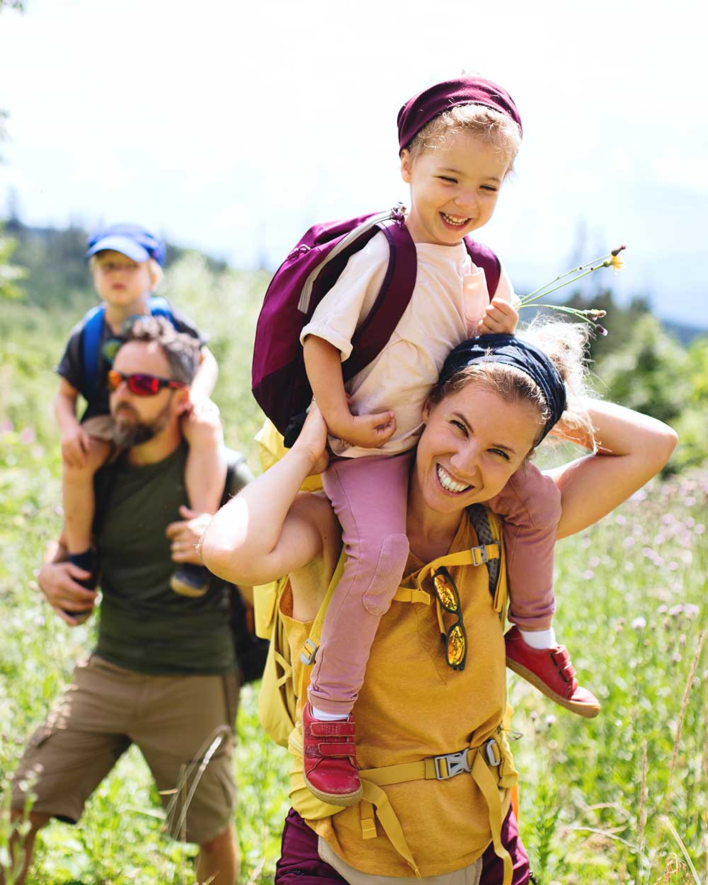 Familie mit kleinen Kindern beim Wandern in der sommerlichen Natur.